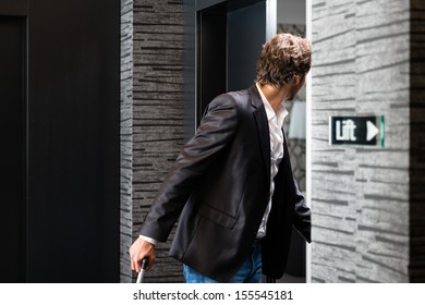 Young Man Standing With A Trolley In Front Of A Room Door In A Hotel