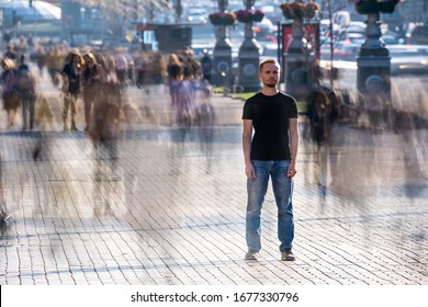 The young man stands in the middle of crowded street