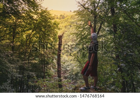 Similar – Hiker woman with backpack raising her arms into the forest