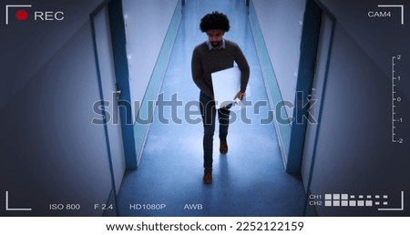 Young Man Stealing Computer Monitor Walking In Building Corridor