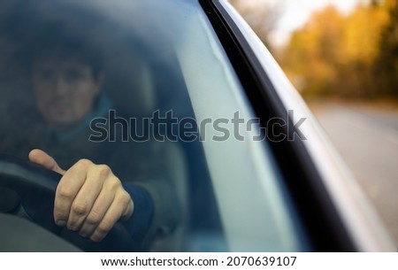 Young man at the steering wheel of his car commuting to work