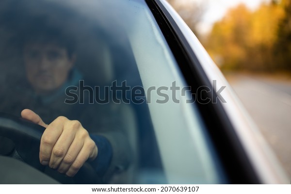 Young man at the steering wheel of his car commuting\
to work