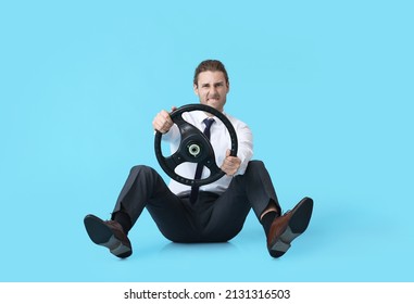 Young Man With Steering Wheel On Color Background