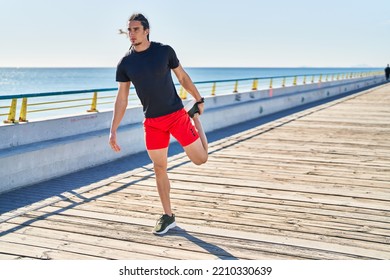 Young Man Stretching Legs At Seaside