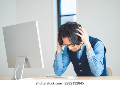 Young man struggling in front of computer