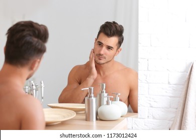 Young man with stubble ready for shaving near mirror in bathroom - Powered by Shutterstock