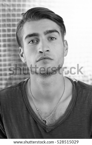 Boy with a white T-shirt in front of a dark wall