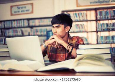 El joven está estudiando para el conocimiento en la biblioteca