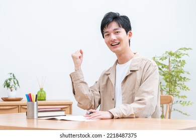 Young man studying in room - Shutterstock ID 2218487375