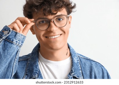 Young man in stylish eyeglasses on light background, closeup - Shutterstock ID 2312912633