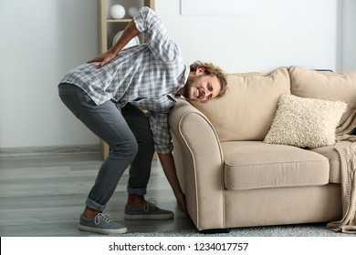 Young Man Suffering From Back Pain After Carrying Heavy Furniture