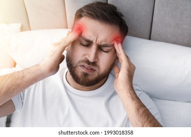 Young Man Suffering From Migraine In Bed, Above View