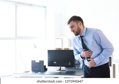 Young man suffering from stomachache in office - Shutterstock ID 1371945647