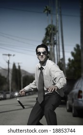 Young Man In Suit Dueling With Nun Chucks