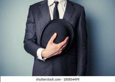 Young Man In Suit Is Holding A Bowler Hat