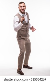 Young Man In Suit Singing Over The Microphone With Energy. Isolated On White Background. Singer Concept.