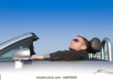 Young Man In Suit Sitting In His Open Sports Car Convertible.