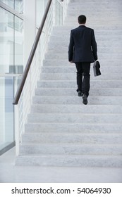 Young Man With A Suitcase Climbing Stairs