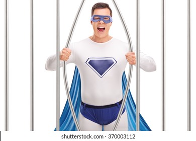 Young Man In Superhero Costume Breaking Out Of Prison By Bending The Bars Isolated On White Background