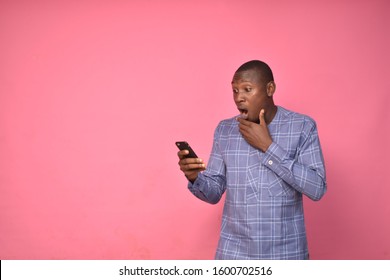 A Young Man Suprised After Looking At His Mobile Phone To Express Happiness 