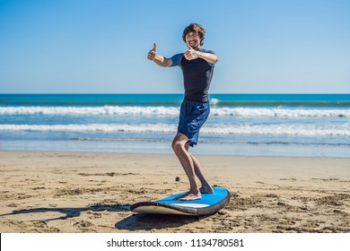 Young Man Surfer Training Before Go To Lineup On A Sand Beach. Learning To Surf. Vacation Concept. Summer Holidays. Tourism, Sport.