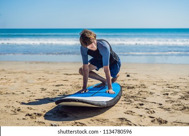 Young Man Surfer Training Before Go To Lineup On A Sand Beach. Learning To Surf. Vacation Concept. Summer Holidays. Tourism, Sport.