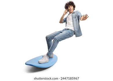 Young man surfing on a surfboard and using a smartphone isolated on white background - Powered by Shutterstock