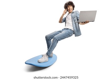 Young man surfing on a surfboard and using a smartphone and holding a laptop computer isolated on white background - Powered by Shutterstock