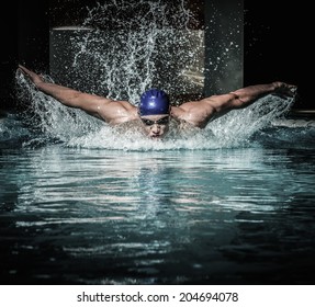 Young man in swimming cap and goggles swim using breaststroke technique 