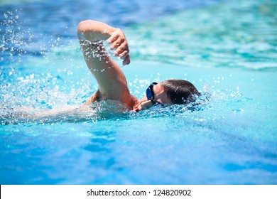 Young man swimming the front crawl in a pool - Powered by Shutterstock