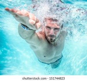 Young man swimming the front crawl in a pool, taken underwater