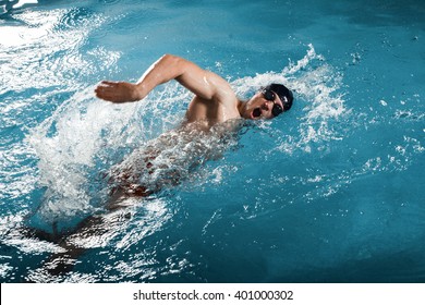 Young man swimming the front crawl in a pool - Powered by Shutterstock