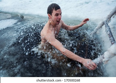 Young Man Swimming In An Ice Hole In A Winter Day