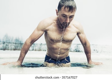 Young man swimming in the ice hole