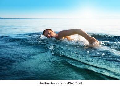 young man swimming in oceans water - Powered by Shutterstock