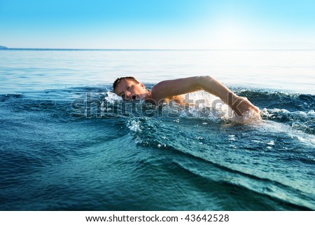 young man swimming in oceans water