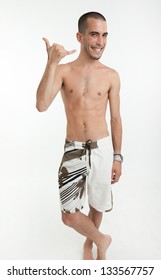 Young Man In Swimming Trunks Doing The Shaka Sign