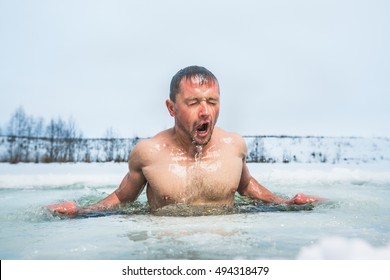 Young Man Swimming In The Winter Lake In The Ice Hole