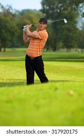 Young Man Swinging Golf Club