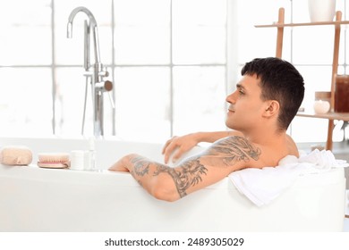 Young man taking bath in room - Powered by Shutterstock