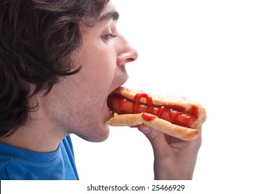 young man taking a bite of a hot dog