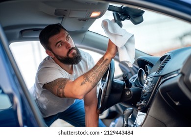 Young Man Taking Care And Cleaning Interior His New Car.