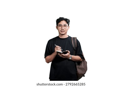 Young Man Taking Notes in Notebook While Wearing Backpack