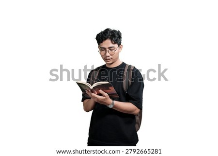 Young Man Taking Notes in Notebook While Wearing Backpack