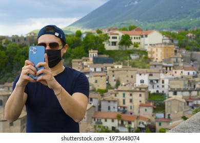 Young man taking a photo with iPhone 12 pro max in Italian town
