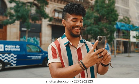 Young man taking photo on cellphone on summer day outdoors