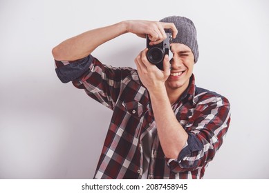 Der junge Mann macht ein Foto mit einer alten Kamera.