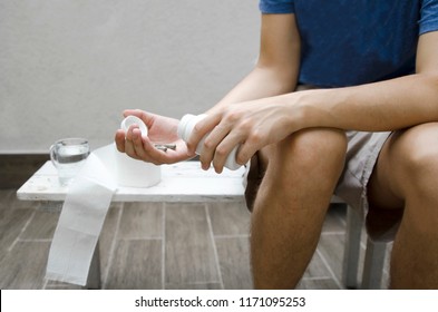 Young Man Taking Probiotic Pills For Stomach Digestion And Diarrhea