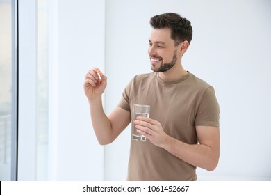 Young Man Taking Vitamin Indoors