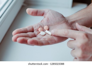 Young Man Taking Vitamins Ginseng Pill